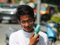 A man is cooling off with a battery fan on a hot summer day in Srinagar, Jammu and Kashmir, on July 01, 2024. (