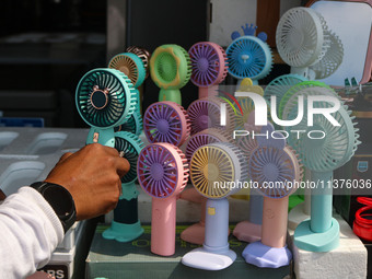 A man is arranging battery fans on a hot summer day in Srinagar, Jammu And Kashmir, on July 01, 2024. (