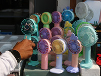 A man is arranging battery fans on a hot summer day in Srinagar, Jammu And Kashmir, on July 01, 2024. (