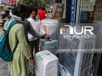 People are checking water cooling fans on a hot summer day in Srinagar, Jammu And Kashmir, on July 01, 2024. (