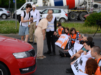 A woman is arguing with climate activists from the Last Generation (Ostatnia Generacja) as they are blocking a main road to protest against...