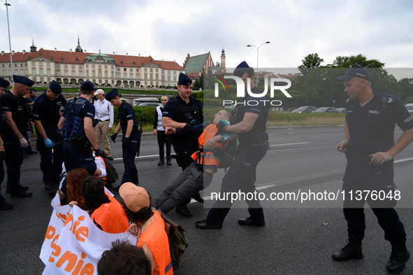 Police officers are detaining climate activists from the Last Generation (Ostatnia Generacja) as they are blocking a main road to protest ag...