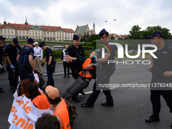 Police officers are detaining climate activists from the Last Generation (Ostatnia Generacja) as they are blocking a main road to protest ag...