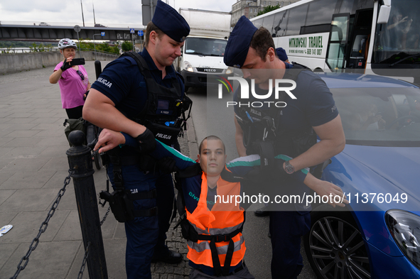 Police officers are detaining climate activists from the Last Generation (Ostatnia Generacja) as they are blocking a main road to protest ag...