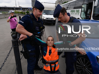 Police officers are detaining climate activists from the Last Generation (Ostatnia Generacja) as they are blocking a main road to protest ag...