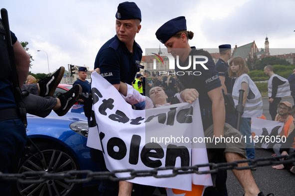 Police officers are detaining climate activists from the Last Generation (Ostatnia Generacja) as they are blocking a main road to protest ag...