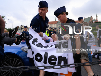 Police officers are detaining climate activists from the Last Generation (Ostatnia Generacja) as they are blocking a main road to protest ag...