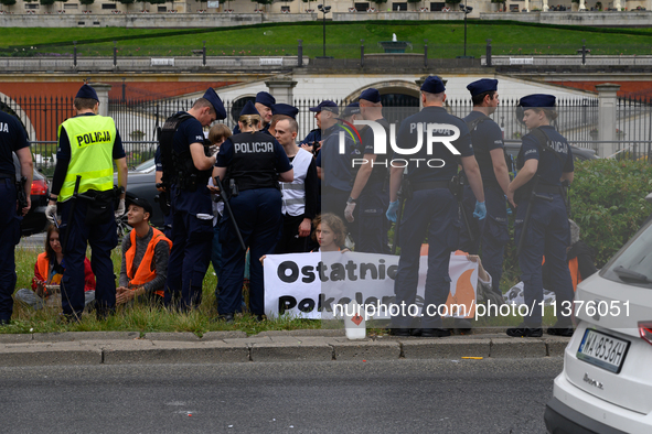 Police officers are detaining climate activists from the Last Generation (Ostatnia Generacja) as they are blocking a main road to protest ag...