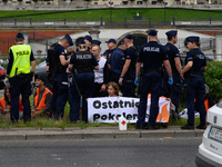 Police officers are detaining climate activists from the Last Generation (Ostatnia Generacja) as they are blocking a main road to protest ag...