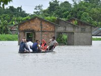 Villagers are paddling their boat near a submerged house in a village in Nagaon District of Assam, India, on July 1, 2024. (