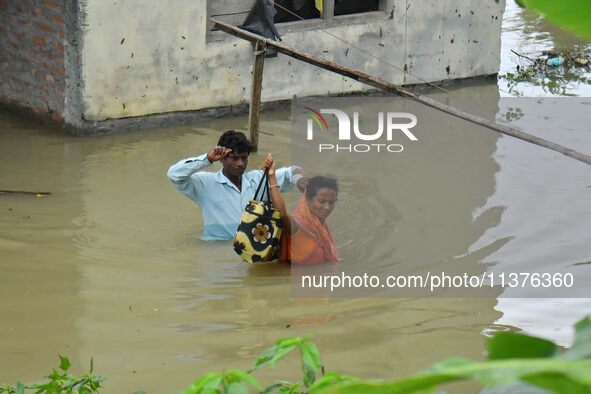 People are shifting their belongings to a safer place following a heavy rainfall in Nagaon District of Assam, India, on July 1, 2024. 