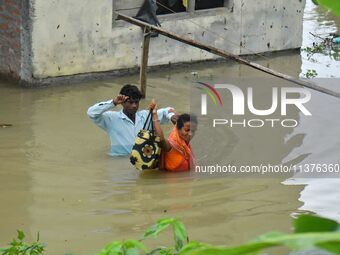 People are shifting their belongings to a safer place following a heavy rainfall in Nagaon District of Assam, India, on July 1, 2024. (