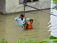 People are shifting their belongings to a safer place following a heavy rainfall in Nagaon District of Assam, India, on July 1, 2024. (