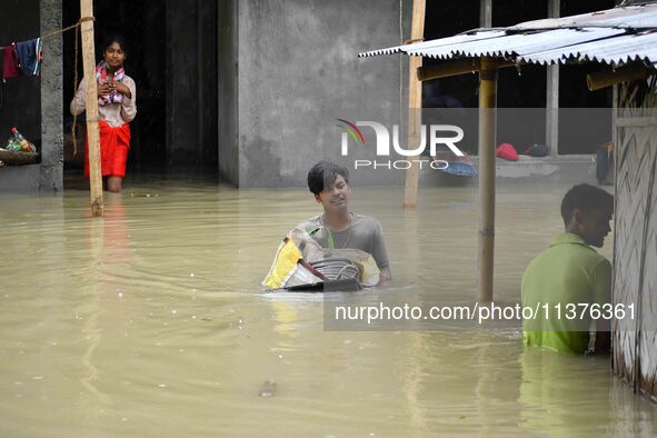 People are shifting their belongings to a safer place following a heavy rainfall in Nagaon District of Assam, India, on July 1, 2024. 