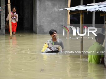 People are shifting their belongings to a safer place following a heavy rainfall in Nagaon District of Assam, India, on July 1, 2024. (