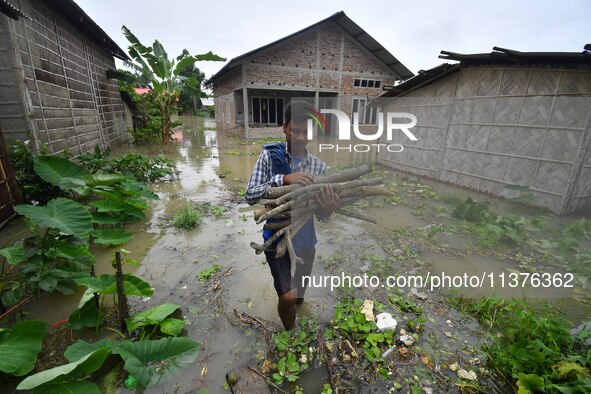 A villager is shifting his belongings to a safer place following a heavy rainfall in Nagaon District of Assam, India, on July 1, 2024. 