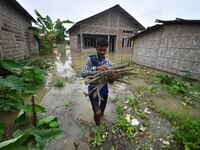 A villager is shifting his belongings to a safer place following a heavy rainfall in Nagaon District of Assam, India, on July 1, 2024. (