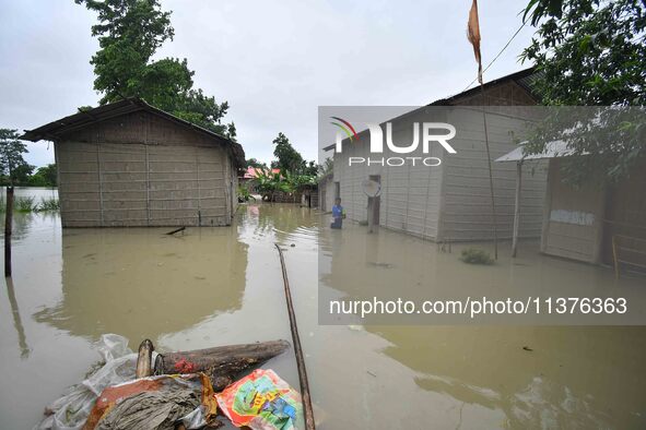 A man is walking through a flooded area in a village in Nagaon District of Assam, India, on July 1, 2024. 