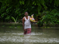 A man is walking through a flooded area in a village in Nagaon District of Assam, India, on July 1, 2024. (