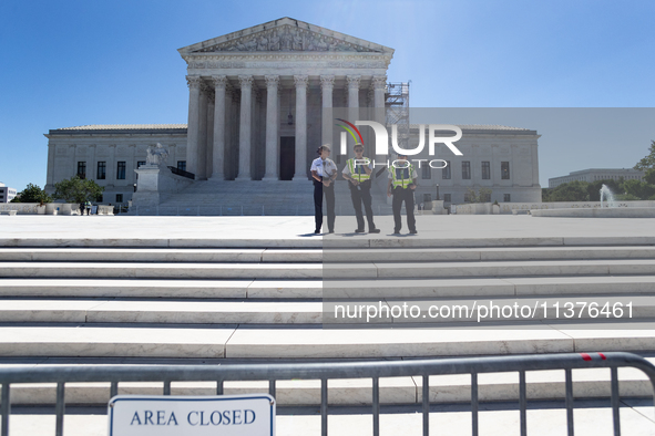 U. S. Supreme Court Police guard the plaza in front of the Court after it issued the last remaining opinions of the term, including a decisi...