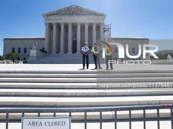 U. S. Supreme Court Police guard the plaza in front of the Court after it issued the last remaining opinions of the term, including a decisi...