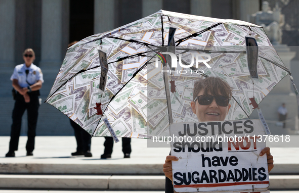 The umbrella of a demonstrator against corrupt Justices is seen in front of U.S. Supreme Court Police guarding the plaza in front of the Cou...