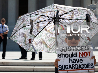 The umbrella of a demonstrator against corrupt Justices is seen in front of U.S. Supreme Court Police guarding the plaza in front of the Cou...