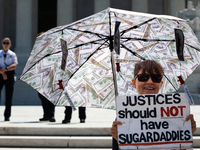 The umbrella of a demonstrator against corrupt Justices is seen in front of U.S. Supreme Court Police guarding the plaza in front of the Cou...