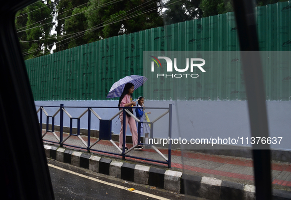 School students are carrying umbrellas during heavy rainfall in Darjeeling, India, on July 1, 2024. Darjeeling is a famous tourist destinati...