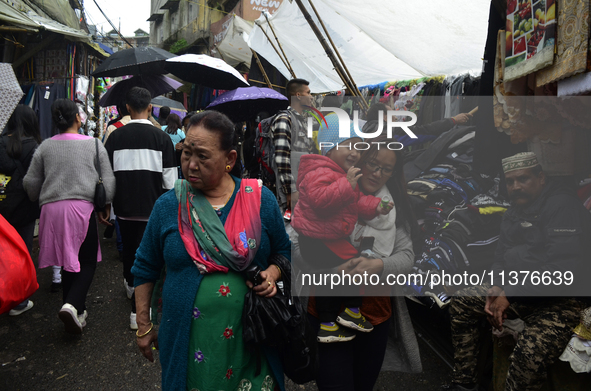 People are being seen in a market area during rainfall in Darjeeling, India, on July 1, 2024. Darjeeling is a famous tourist destination in...