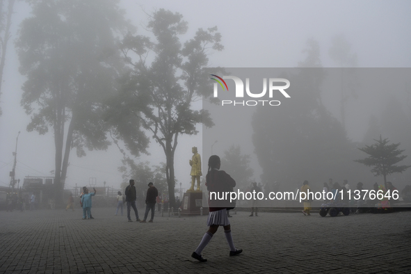 A man is passing through dense cloud on Mall Road in Darjeeling, India, on July 1, 2024. Darjeeling is a famous tourist destination in North...