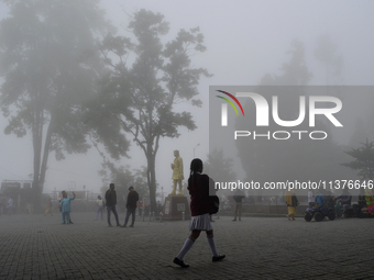 A man is passing through dense cloud on Mall Road in Darjeeling, India, on July 1, 2024. Darjeeling is a famous tourist destination in North...