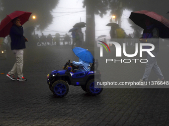 Pedestrians are carrying umbrellas during heavy rainfall in Darjeeling, India, on July 1, 2024. Darjeeling is a famous tourist destination i...