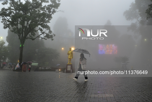 A pedestrian is carrying an umbrella during heavy rainfall in Darjeeling, India, on July 1, 2024. Darjeeling is a famous tourist destination...