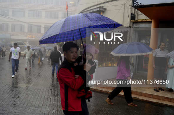 Pedestrians are carrying umbrellas during heavy rainfall in Darjeeling, India, on July 1, 2024. Darjeeling is a famous tourist destination i...