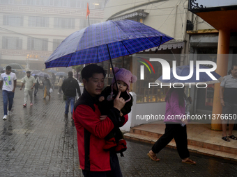 Pedestrians are carrying umbrellas during heavy rainfall in Darjeeling, India, on July 1, 2024. Darjeeling is a famous tourist destination i...