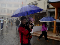 Pedestrians are carrying umbrellas during heavy rainfall in Darjeeling, India, on July 1, 2024. Darjeeling is a famous tourist destination i...