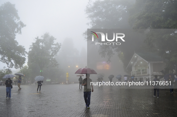 Pedestrians are carrying umbrellas during heavy rainfall in Darjeeling, India, on July 1, 2024. Darjeeling is a famous tourist destination i...