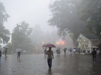 Pedestrians are carrying umbrellas during heavy rainfall in Darjeeling, India, on July 1, 2024. Darjeeling is a famous tourist destination i...