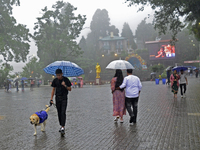 Pedestrians are carrying umbrellas during heavy rainfall in Darjeeling, India, on July 1, 2024. Darjeeling is a famous tourist destination i...