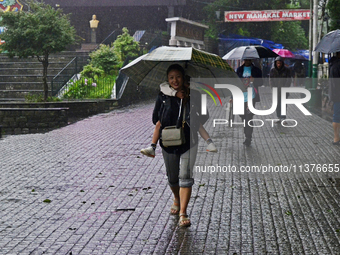 Pedestrians are carrying umbrellas during heavy rainfall in Darjeeling, India, on July 1, 2024. Darjeeling is a famous tourist destination i...