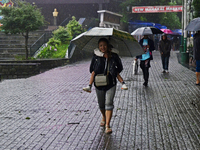 Pedestrians are carrying umbrellas during heavy rainfall in Darjeeling, India, on July 1, 2024. Darjeeling is a famous tourist destination i...