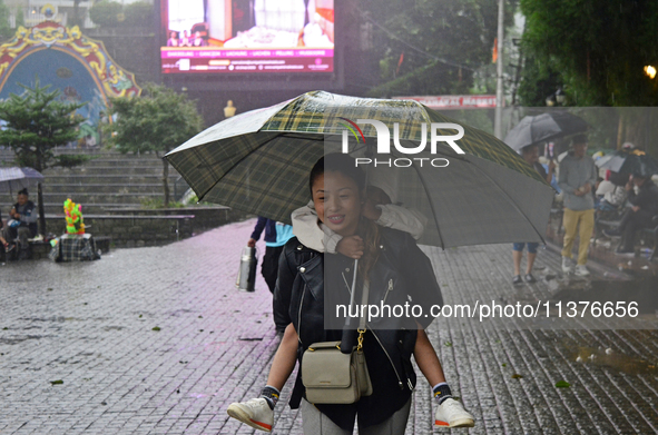 Pedestrians are carrying umbrellas during heavy rainfall in Darjeeling, India, on July 1, 2024. Darjeeling is a famous tourist destination i...