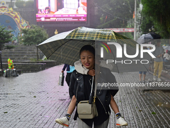 Pedestrians are carrying umbrellas during heavy rainfall in Darjeeling, India, on July 1, 2024. Darjeeling is a famous tourist destination i...