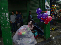 A toy seller is taking shelter during heavy rainfall in Darjeeling, India, on July 1, 2024. Darjeeling is a famous tourist destination in No...