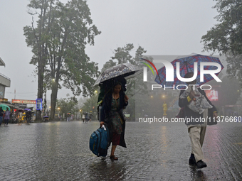 Pedestrians are carrying umbrellas during heavy rainfall in Darjeeling, India, on July 1, 2024. Darjeeling is a famous tourist destination i...