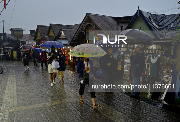 Pedestrians are carrying umbrellas during heavy rainfall in Darjeeling, India, on July 1, 2024. Darjeeling is a famous tourist destination i...