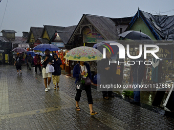 Pedestrians are carrying umbrellas during heavy rainfall in Darjeeling, India, on July 1, 2024. Darjeeling is a famous tourist destination i...