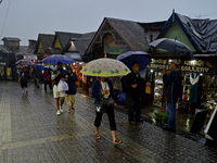 Pedestrians are carrying umbrellas during heavy rainfall in Darjeeling, India, on July 1, 2024. Darjeeling is a famous tourist destination i...