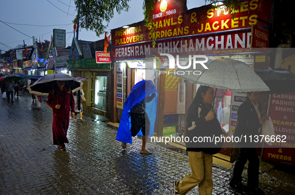 Pedestrians are carrying umbrellas during heavy rainfall in Darjeeling, India, on July 1, 2024. Darjeeling is a famous tourist destination i...